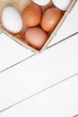 Farm Fresh Brown Chicken Hen Eggs in a Basket on Rustic Wood Counter Background with Copyspace, vertical