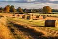 a farm with haystacks and ripe cornfields in autumn sunshine
