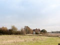 Farm house cottage in the distance beyond field Royalty Free Stock Photo