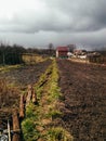 A farm house on the country side. road to a farmhouse in a dug-out land. rain, thunderclouds Royalty Free Stock Photo