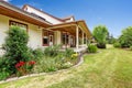 Farm house exterior. Entrance porch with beautiful flower bed
