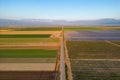 Farm landscape aerial view, Country road passing through different fields near Bakersfield, California