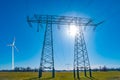 Farm landscape with big electrical power lines and wind turbine to produce green energy in Germany, Summer, at blue sky, direct Royalty Free Stock Photo