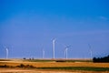 Farm landscape. Windmills operate in desert field. Clear sky, warm Sunny day