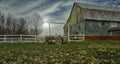 This farm machinery is near a barn. The horses at the back of their pens ate. Photo taken during the day near my home. Roxton Royalty Free Stock Photo