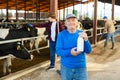 Farm owner and workers in cowhouse