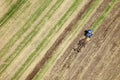 An aerial view of a tractor plowing in a field.