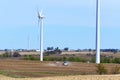 Farm scene with a tractor seeding a farm fields amongst wind towers