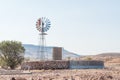 Farm scene with water-pumping windmill and dam at Bergsig