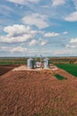 Farm silos in field, aerial view from drone pov on sunny spring day Royalty Free Stock Photo