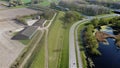 Farm situated on a road in green surroundings. Arable land that has been plowed.