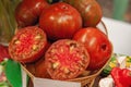 Farm tomatoes in a basket lie in the window of the farmer`s market. The latest hybrid varieties of vegetables. Isolated on black Royalty Free Stock Photo