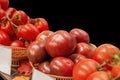 Farm tomatoes in a basket lie in the window of the farmer`s market. The latest hybrid varieties of vegetables. Isolated on black Royalty Free Stock Photo