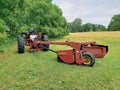 Farm tractor with attached New Holland 1411 mower in front of a