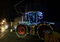 Farm tractor decorated with festive Christmas lights in the street.