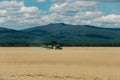 Farm tractor drives in field Royalty Free Stock Photo