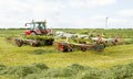 A farm tractor raking hay silage in field