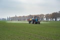 Farm tractor spraying agrochemical or agrichemical over young gr Royalty Free Stock Photo