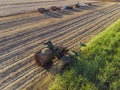 Farm Tractors working on sugar cane harvest plantation aerial view