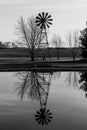 Farm Windmill Silhouette with barren background set against its reflection in a lake II Royalty Free Stock Photo