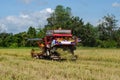 Farm worker harvesting rice with tractor