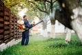 Farm worker spraying pesticide treatment on fruit garden