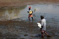 Farm workers throw fertilizer in the paddy fields