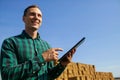 Farmer agronomist with digital tablet computer using mobile app in wheat crops field