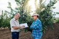 Farmer and agronomist. Senior farmer signs contract to sell plum fruit.