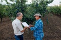 Farmer and agronomist. Senior farmer signs contract to sell plum fruit.