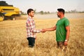 Farmer and agronomist shaking hands in wheat field after agreement. Agriculture business contract concept. Corporate Royalty Free Stock Photo