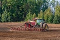 The farmer in the autumn treats the fields with the tractor and enriches them with mineral fertilizers.