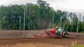 The farmer in the autumn treats the fields with the tractor and enriches them with mineral fertilizers.