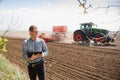 Farmer on background of tractor sowing field. Work in the field. Agriculture concept. Farm work in the field in spring Royalty Free Stock Photo