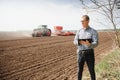 Farmer on background of tractor sowing field. Work in the field. Agriculture concept. Farm work in the field in spring Royalty Free Stock Photo