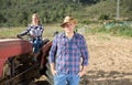 Farmer on background with wife on tractor Royalty Free Stock Photo