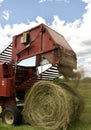 A farmer bales hay in a lush Minnesota field.