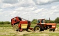 A farmer bales hay in a pastoral setting on a Minnesota farm.