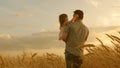 Farmer carries a little daughter in his arms through a field of wheat. happy child and father are playing in field of Royalty Free Stock Photo