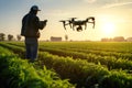 A farmer controls a drone over an agricultural field. Digital transformation of farming