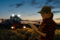 Farmer controls sprayer with a tablet at night.