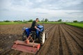 A farmer cultivates a field with a tractor after harvest. Milling soil, crushing before cutting rows. Farming, agriculture