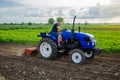 A farmer is cultivating a farm field. Milling soil, crushing before cutting rows. Farming, agriculture. Loosening surface, land