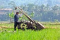 A FARMER cultivating a field with a modern plow before the planting season arrives in the rice fields around Rawa Pening