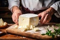 A farmer demonstrates a piece of cheese he made with his own hands. Homemade cheese production on a farm. Natural product. Close-