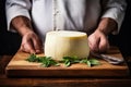 A farmer demonstrates a piece of cheese he made with his own hands. Homemade cheese production on a farm. Natural product. Close- Royalty Free Stock Photo