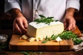 A farmer demonstrates a piece of cheese he made with his own hands. Homemade cheese production on a farm. Natural product. Close-