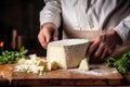 A farmer demonstrates a piece of cheese he made with his own hands. Homemade cheese production on a farm. Natural product. Close-