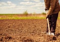 Farmer digging spring farmland soil