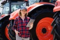 Farmer with a digital tablet on the background of an agricultural tractors Royalty Free Stock Photo